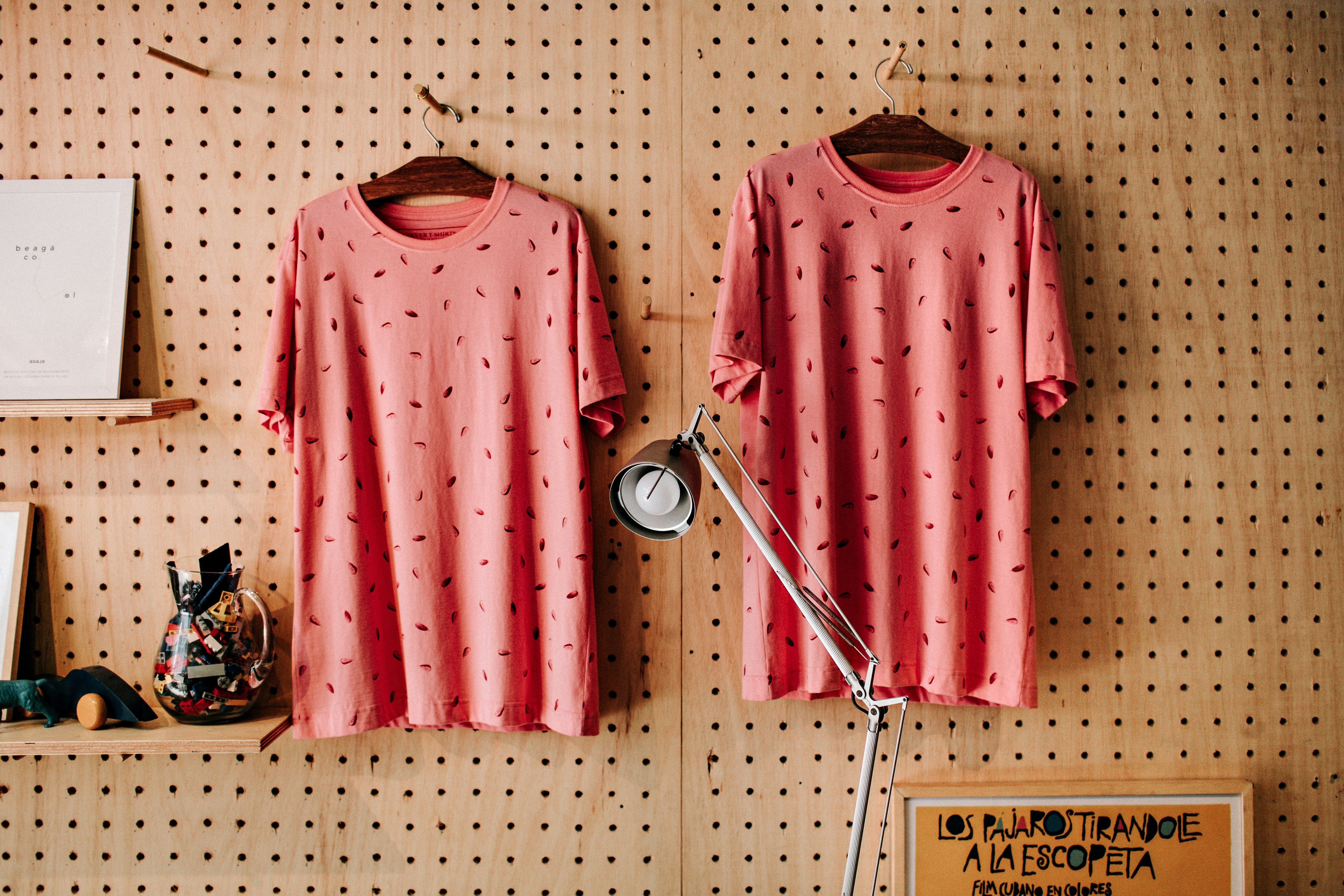 two red-and-black foliage crew-neck T-shirts hanging on hanger